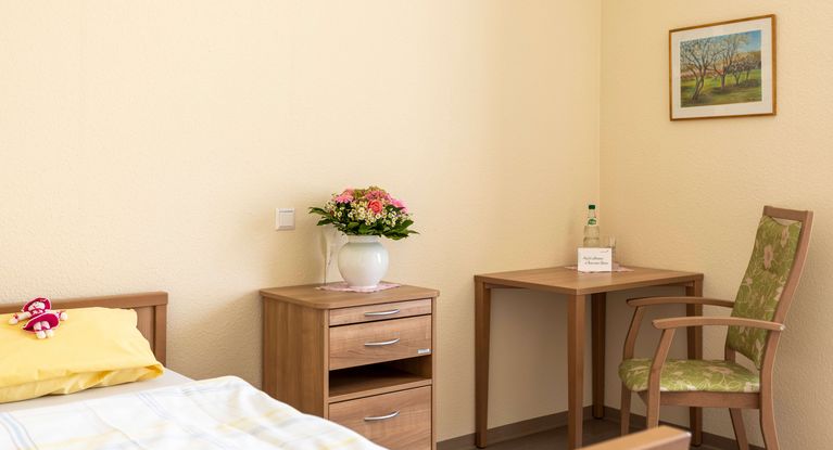 Einzelzimmer mit Bett,Stühlen und Nachttisch