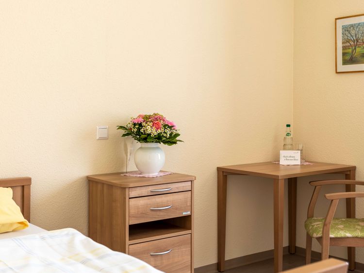 Einzelzimmer mit Bett,Stühlen und Nachttisch