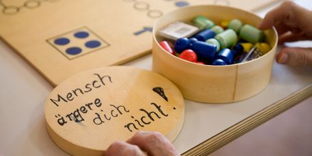 Spielbrett mit bunten Mensch ärgere dich nicht Figuren